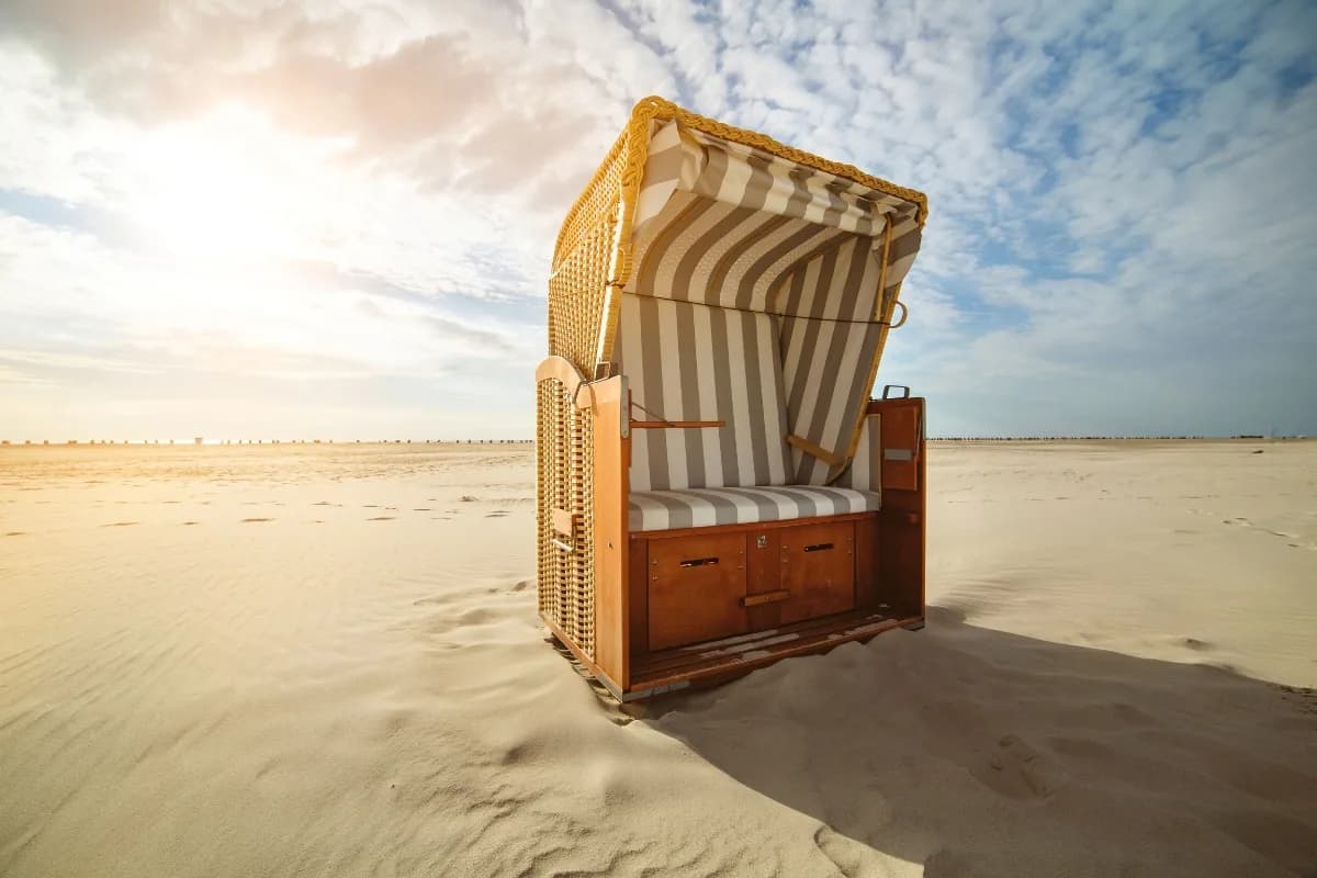Strandkorb auf dem weiten Sandstrand von St. Peter-Ording im Abendlicht